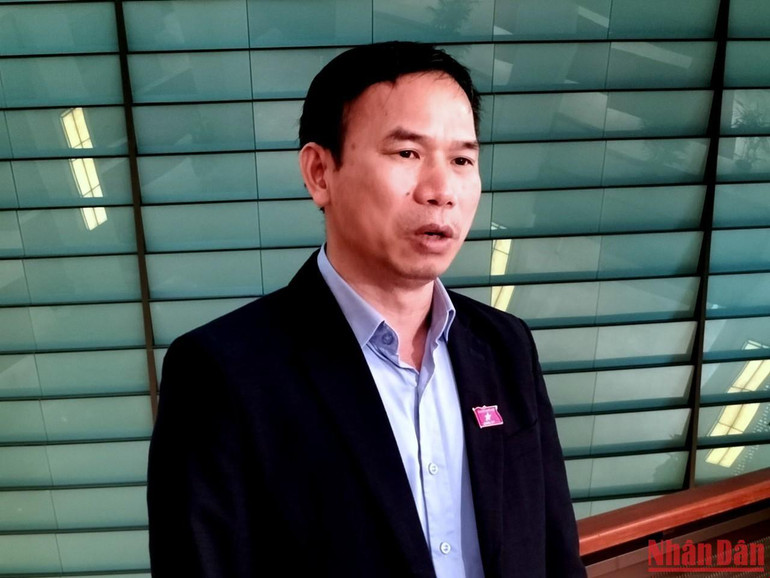 Đại biểu Đồng Ngọc Ba (Bình Định) trao đổi bên hành lang Quốc hội. (Ảnh: TRUNG HƯNG)