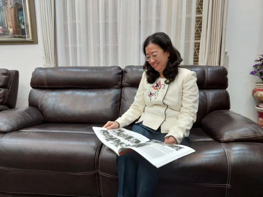 Đại sứ Hà Thị Ngọc Hà cho phóng viên xem lại các bức ảnh tư liệu của Đại sứ Hà Văn Lâu. (Ảnh: TTXVN)