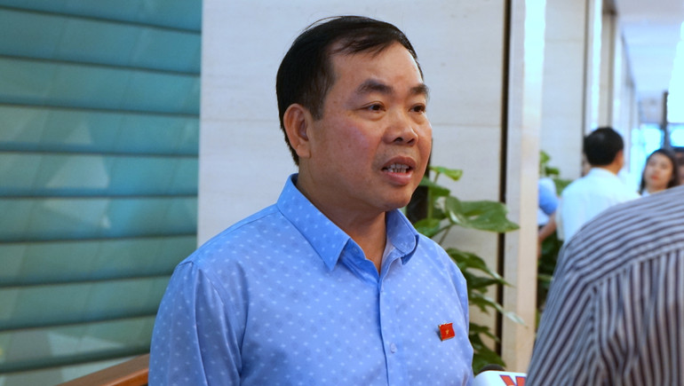 Đại biểu Nguyễn Quang Huân (Bình Dương) trao đổi bên hành lang Quốc hội. (Ảnh: TRUNG HƯNG)