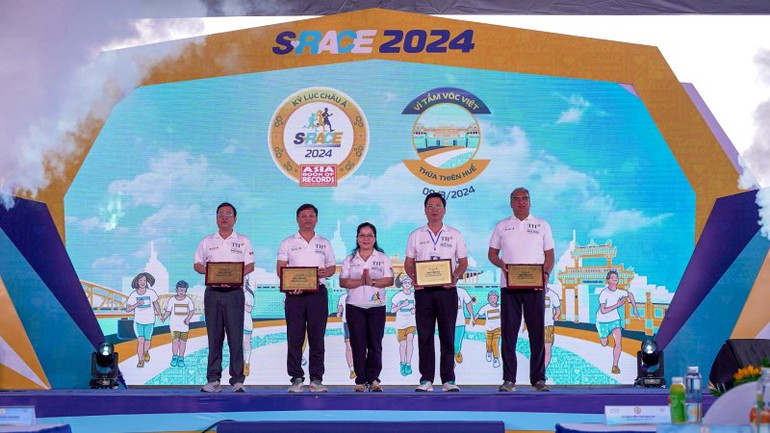 Thứ trưởng Giáo dục và Đào tạo Nguyễn Thị Kim Chi (giữa) trao bảng vinh danh cảm ơn tỉnh Thừa Thiên Huế và Tập đoàn TH đã đồng hành cùng Giải chạy S-Race 2024.