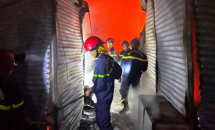 Cảnh sát chữa cháy phá ki-ốt để cứu tài sản của tiểu thương và khống chế đám cháy.