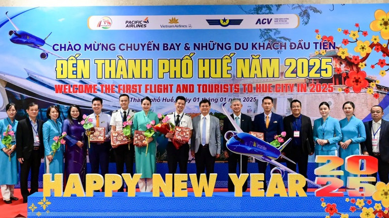 Lãnh đạo thành phố Huế và ngành du lịch chụp ảnh cùng nhóm hành khách đầu tiên cùng cơ trưởng và tiếp viên trưởng của chuyến bay.