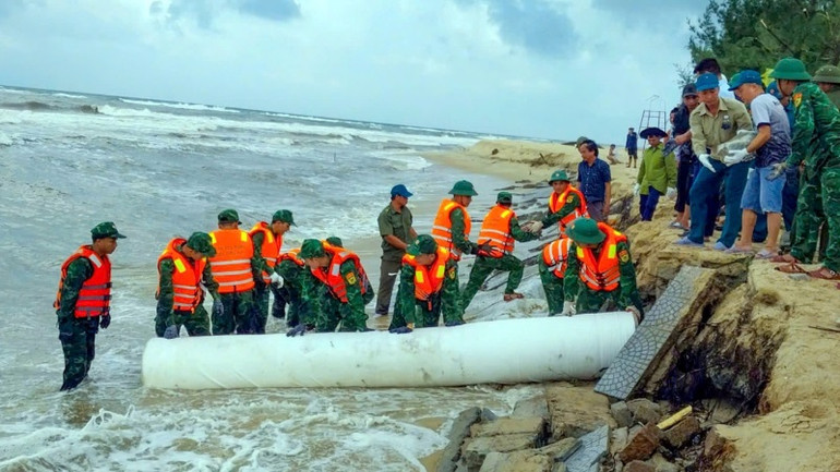 Cán bộ, chiến sĩ Bộ đội Biên phòng Thừa Thiên Huế tham gia khắc phục sạt lở bờ biển trên địa bàn phường Thuận An, thành phố Huế. (ảnh: Võ Tiến)