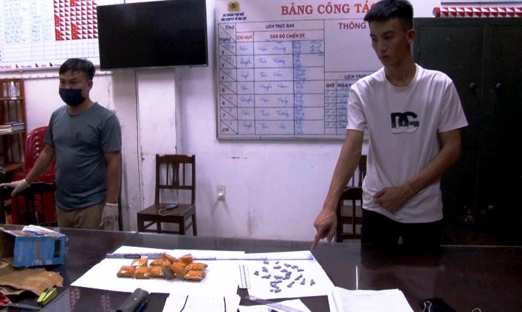 Đối tượng Nguyễn Việt Đức (áo trắng bên phải) cùng tang vật. Đối tượng Nguyễn Việt Đức (áo trắng bên phải) cùng tang vật.