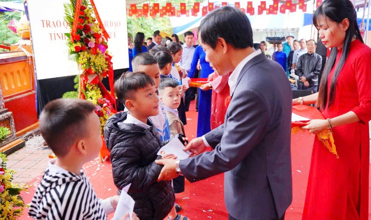 Chủ tịch Ủy ban nhân dân tỉnh Nguyễn Văn Phương trao quà tặng các em học sinh nghèo.