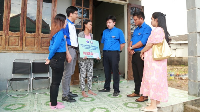 Tặng quà bà Nguyễn Thị Vân có nhà bị thiệt hại nặng do mưa lớn kèm lốc xoáy trong đợt mưa lũ vừa qua ở thị trấn Lăng Cô (huyện Phú Lộc). (Ảnh: BVH)