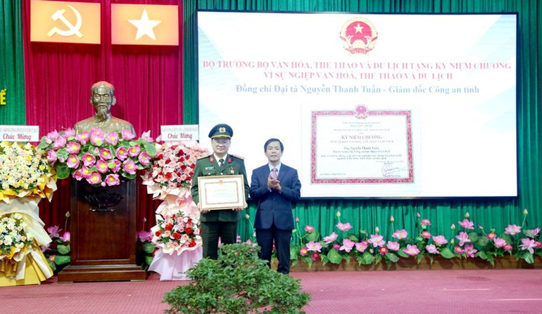 Chủ tịch Ủy ban nhân dân tỉnh Nguyễn Văn Phương trao Kỷ niệm chương của Bộ trưởng Văn hóa, Thể thao và Du lịch tặng Đại tá Nguyễn Thanh Tuấn, Giám đốc Công an tỉnh.