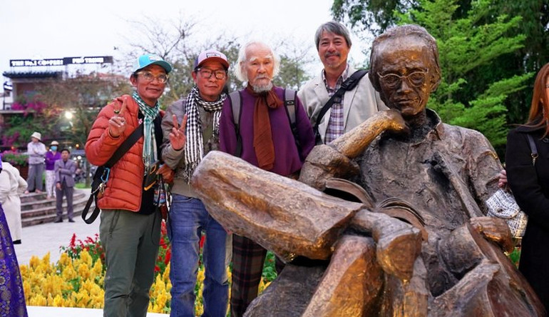 Các nghệ sỹ, bạn bè, thân hữu gia đình cố nhạc sĩ Trịnh Công Sơn chụp ảnh lưu niệm bên tượng Trịnh Công Sơn.