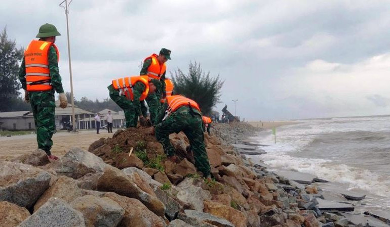 Cán bộ, chiến sĩ Bộ đội Biên phòng vận chuyển đá để gia cố các điểm bị sạt lở. (Ảnh: VT)