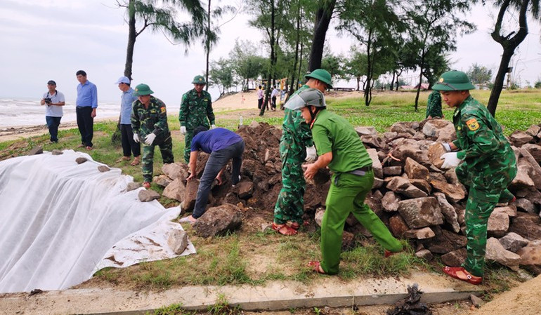 Cán bộ, chiến sĩ Đồn Biên phòng Vinh Xuân cùng lực lượng Công an, dân quân địa phương tích cực vận chuyển các bao tải cát, chèn đá... khẩn trương khắc phục điểm sạt lở bờ biển do mưa lớn gây ra.