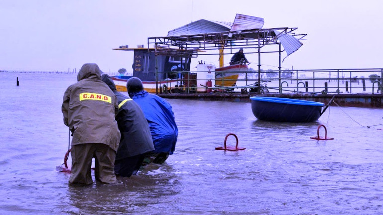 Lực lượng chức năng hỗ trợ người dân tập kết tàu thuyền, tài sản, lương thực lên chỗ khô ráo.