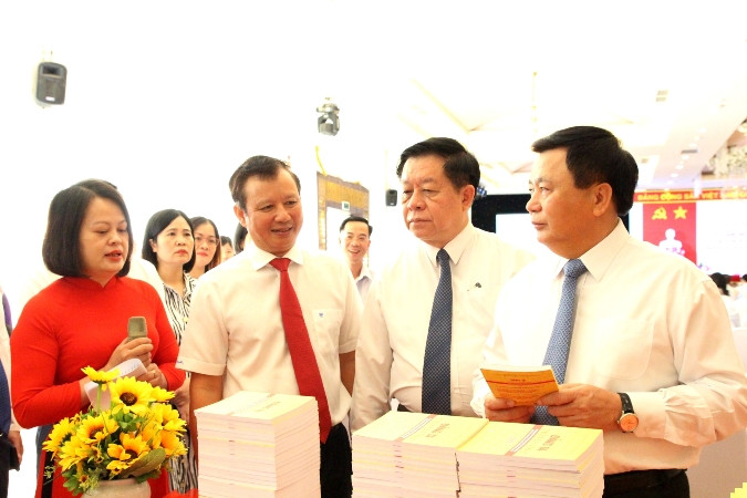 Ủy viên Bộ Chính trị, Giám đốc Học viện Chính trị quốc gia Hồ Chí Minh Nguyễn Xuân Thắng; Bí thư Trung ương Đảng, Trưởng Ban Tuyên giáo Trung ương Nguyễn Trọng Nghĩa và Bí thư Tỉnh ủy Thừa Thiên Huế Lê Trường Lưu cùng các đại biểu tham quan gian sách trưng bày Lịch sử Đảng bộ các địa phương.