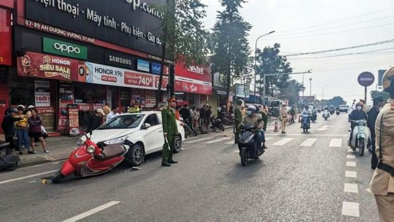 Chiếc xe máy còn mắc kẹt trước đầu xe taxi. Ảnh: CTV