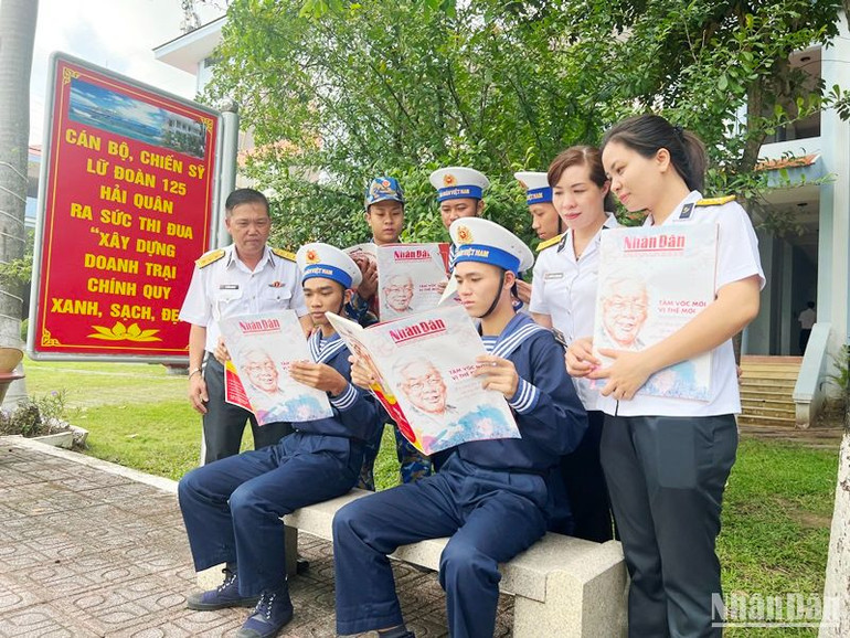 Cán bộ, chiến sĩ đọc những thông tin ý nghĩa trên ấn phẩm Báo Nhân Dân Xuân Quý Mão 2023 trong khuôn viên đơn vị.