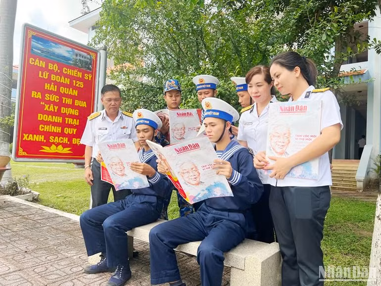 Cán bộ, chiến sĩ đọc những thông tin ý nghĩa trên ấn phẩm Báo Nhân Dân Xuân Quý Mão 2023 trong khuôn viên đơn vị.