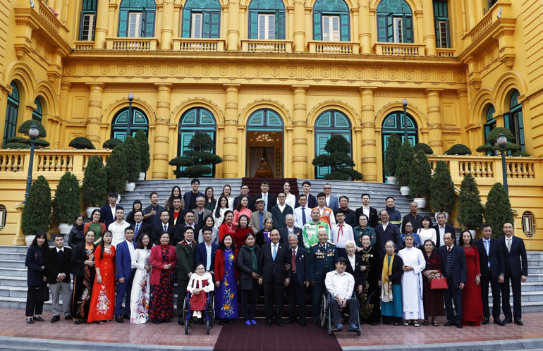 Chủ tịch nước Nguyễn Xuân Phúc cùng các nhân vật trong Chương trình "Việc tử tế" của Đài Truyền hình Việt Nam trong năm 2022. (Ảnh: TTXVN)