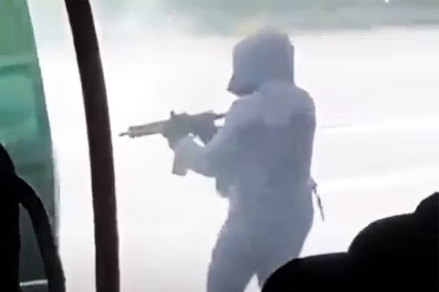 Nhóm người bịt mặt, mặc đồ đen nã súng vào các nhân viên an ninh. (Ảnh chụp màn hình)