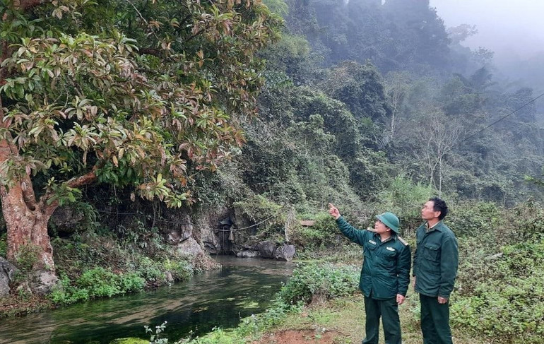 Ông Lang Văn Chuẩn (bên phải) cùng một cán bộ biên phòng Bát Mọt (huyện Thường Xuân, tỉnh Thanh Hóa) trên đường tuần tra. Ảnh: HẢI NGUYỄN