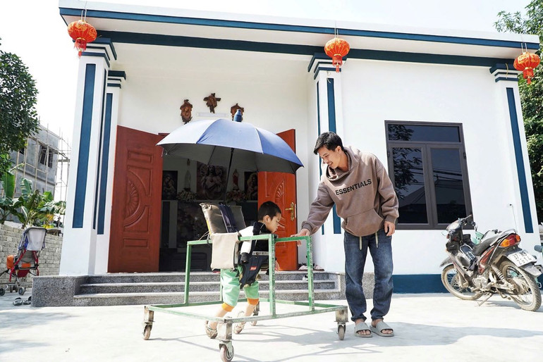 Anh Phạm Hồng Huy bên ngôi nhà mới do cộng đoàn giáo dân giáo xứ Đông Sơn đóng góp xây dựng.