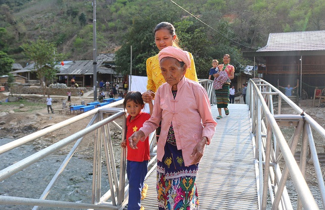 Dân bản vui mừng khi đi qua cầu vượt lũ.