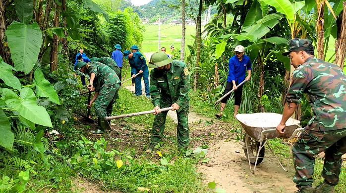 Phát quang lối đi lại, làm vườn, dọn dẹp nhà cửa cho các gia đình chính sách ở dọc tuyến biên giới.