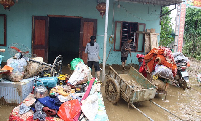 Người dân giúp nhau dọn dẹp đồ đạc, vệ sinh môi trường sau lũ.