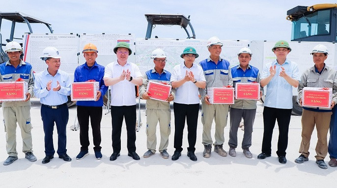 Tặng quà cho công nhân đang thi công. (Ảnh: PHẠM BẰNG)