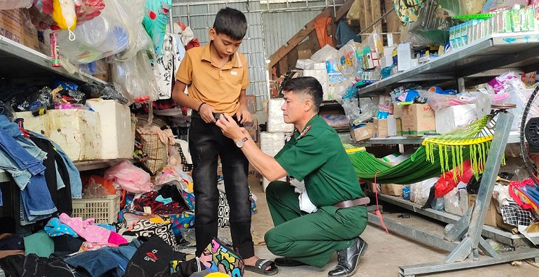 Bố nuôi Biên phòng đang sắm quần áo mới cùng đồ dùng học tập để con nuôi tự tin bước vào năm học mới.