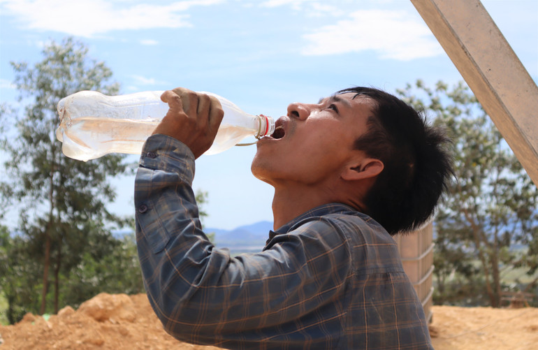 Làm việc dưới thời tiết nắng nóng, các công nhân phải liên tục bổ sung nước.