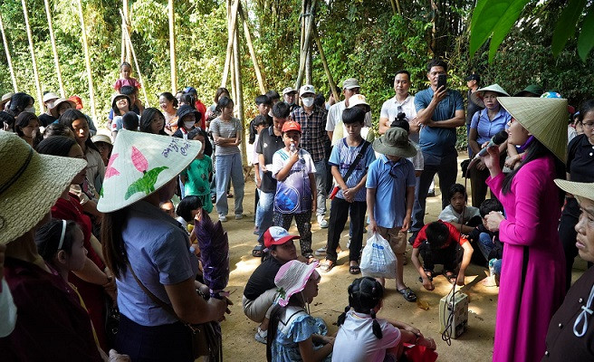 Du khách được hướng dẫn viên giới thiệu về thời niên thiếu của Bác Hồ tại quê nội.