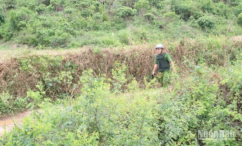 Một chiến sĩ Công an đang truy lùng các đối tượng đang lẩn trốn tại suối Cá Ngựa, thôn Đông Sơn, xã Hòa Hiệp, huyện Cư Kuin.