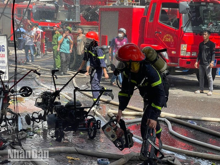 Các cán bộ, chiến sĩ hỗ trợ người dân đưa các vật dụng ra ngoài.