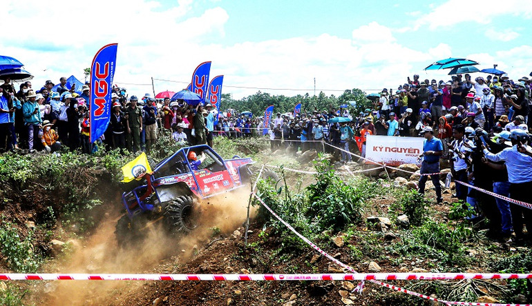 Một xe đua tung bụi mù mịt.