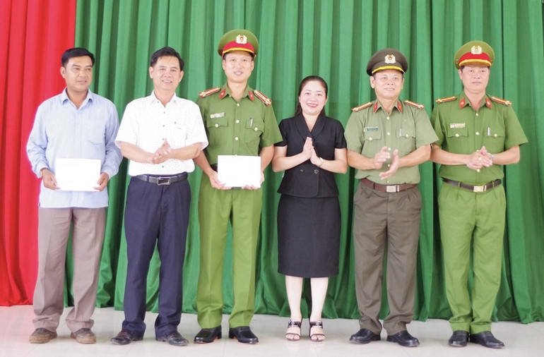 Lãnh đạo Huyện ủy, Ủy ban nhân dân huyện Cư Kuin trao thưởng cho Phòng An ninh nội địa, Công an huyện Cư Kuin và người dân. (Ảnh: Công an cung cấp)