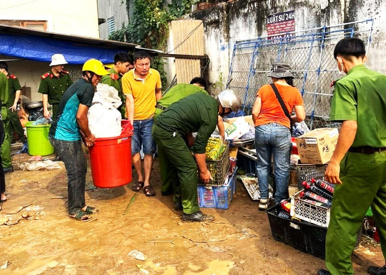 Lực lượng Công an huyện Ea Súp hỗ trợ người dân di chuyển hàng hóa ra khỏi chợ.