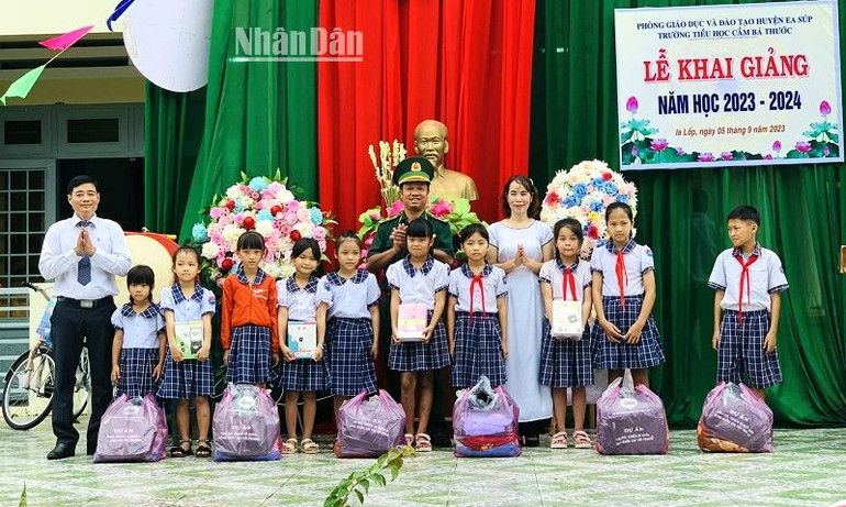 Đại diện Đồn Biên phòng Ea H’Leo và nhà trường trao tặng quà cho các em học sinh tại Trường tiểu học Cầm Bá Thước, xã Ia Lốp, huyện Ea Súp.
