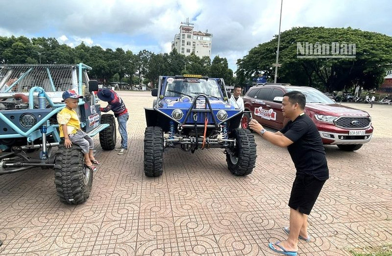 Người hâm mộ xe đua địa hình ở Đắk Lắk đưa con đến chụp hình bên xe đua làm kỷ niệm. Người hâm mộ xe đua địa hình ở Đắk Lắk đưa con đến chụp hình bên xe đua làm kỷ niệm.
