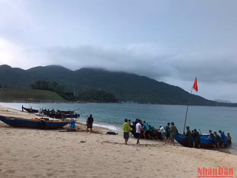 Cán bộ, chiến sĩ Tiểu đoàn 70, Bộ Chỉ huy quân sự tỉnh Quảng Nam hỗ trợ ngư dân đưa phương tiện tránh trú bão.
