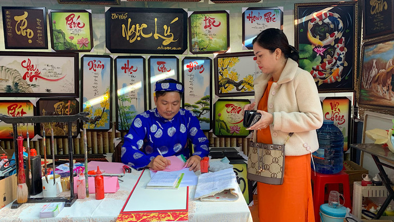 Du khách tham quan gian hàng thư pháp Việt tại Phố ông đồ.