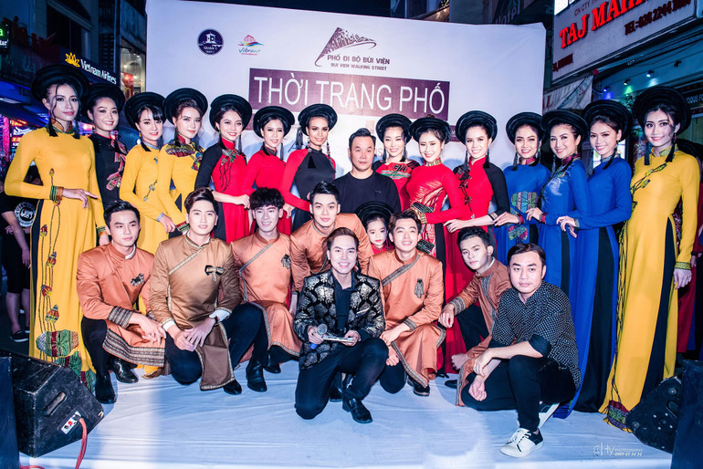 Nguyễn Việt Hùng (đứng giữa) và các người mẫu áo dài tại một sự kiện thời trang.