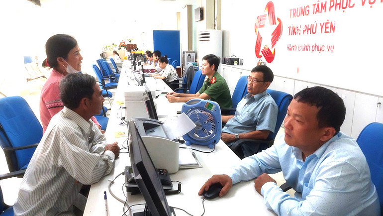 Cán bộ bộ phận một cửa Ủy ban Nhân dân tỉnh Phú Yên giải thích các thắc mắc cho người dân và doanh nghiệp các vấn đề liên quan đến thủ tục hành chính. (Ảnh: PHƯƠNG NAM).