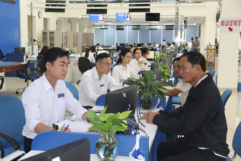 Cán bộ tại một phận một cửa Ủy ban Nhân dân tỉnh Quảng Ngãi tiếp đón và giải quyết hồ sơ cho người dân. (Ảnh: HIỀN CỪ).