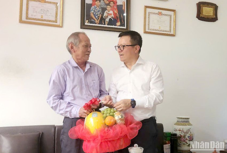 Đồng chí Lê Quốc Minh tặng quà nhà báo lão thành Ngô Quy Nhơn. (Ảnh: ĐÌNH TĂNG)