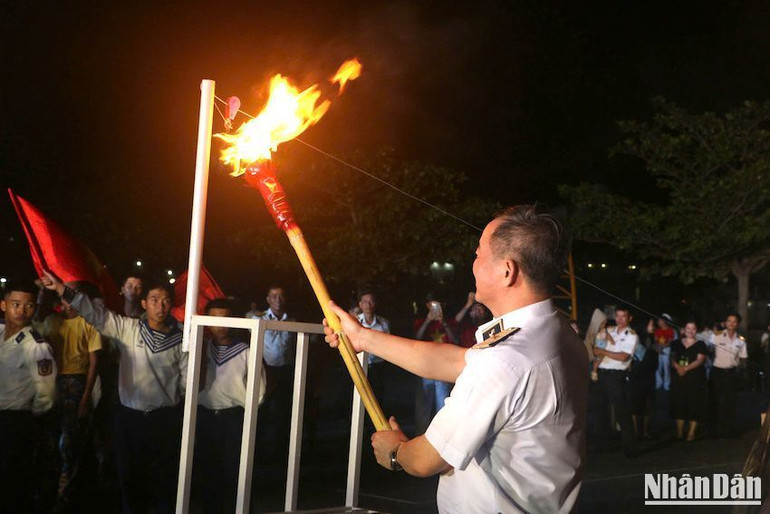 Chuẩn Đô đốc Nguyễn Đăng Tiến, Bí Thư Đảng ủy, Chính ủy Vùng 3 đốt đuốc, trao ngọn lửa cho thế hệ trẻ Vùng 3 Hải quân. (Ảnh: ĐÌNH TĂNG)