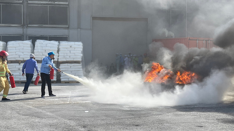 Công nhân Công ty cổ phần Nhựa An Phát Xanh chữa cháy bằng bình chữa cháy nhỏ.
