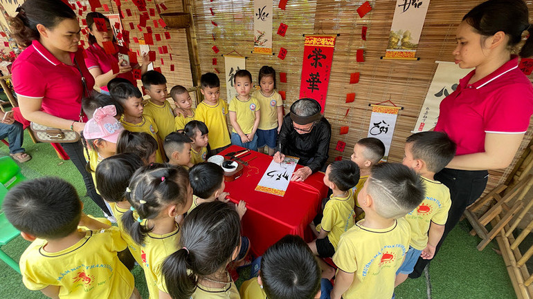 Trẻ 5 tuổi trải nghiệm và xem "thầy đồ" viết thư pháp.