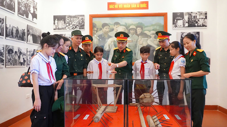 Cán bộ, chiến sĩ lực lượng vũ trang và các em học sinh thăm gian trưng bày hiện vật tại Nhà tưởng niệm Chủ tịch Hồ Chí Minh.