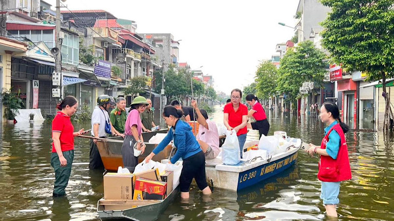Cán bộ thành phố mang quà hỗ trợ các khu dân cư còn trong diện ngập úng.