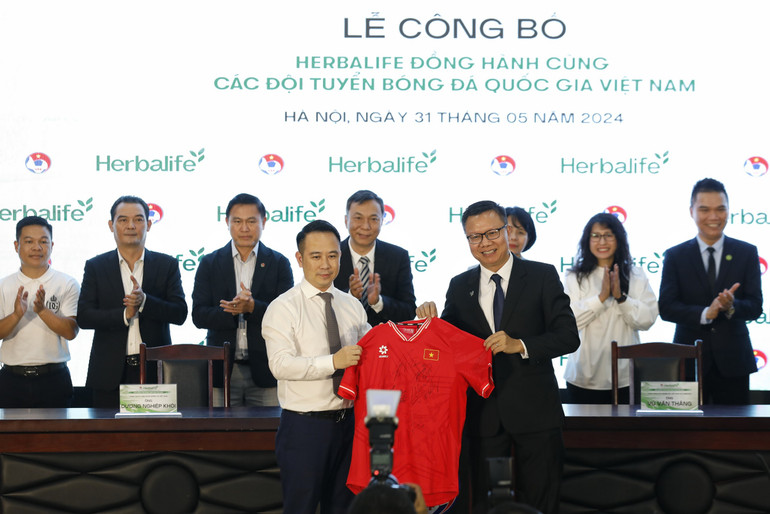 Ông Vũ Văn Thắng (phải) nhận chiếc áo lưu niệm của Đội tuyển Việt Nam.