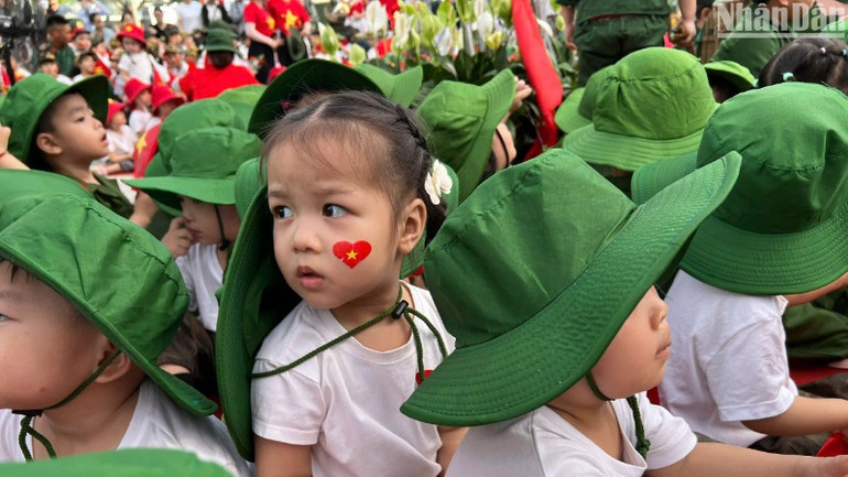 Hình ảnh đáng yêu của một học sinh với trái tim cờ đỏ sao vàng dán trên má. (Ảnh: ANH ĐÀO)